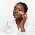 Black woman applying Eucerin Even Radiance Moisturizer on face, brightening dark spot routine — Glow Ritual
