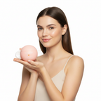 Caucasian female model holding SKINFOOD Peach Cotton Zinc PCA Toning Cream round peach-pink sphere jar, white minimalist background, clear matte skin
