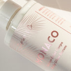 Monaco Body Glow Serum 300ml close-up — soft pink palm leaf label with rose gold text
