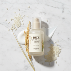 SKINFOOD Rice Brightening Serum flat lay with rice grains and rice stalks on marble surface, K-beauty brightening skincare ingredients
