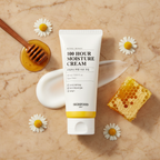 SKINFOOD Royal Honey 100 Hour Moisture Cream with honeycomb honey dipper and chamomile flowers flat lay
