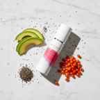 Superfood Oil Serum flat lay with natural ingredients including chia seeds, avocado and seabuckthorn on marble surface
