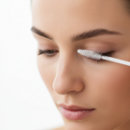 Western woman precisely applying CLIO Kill Lash Mascara Remover brush to eyelashes
